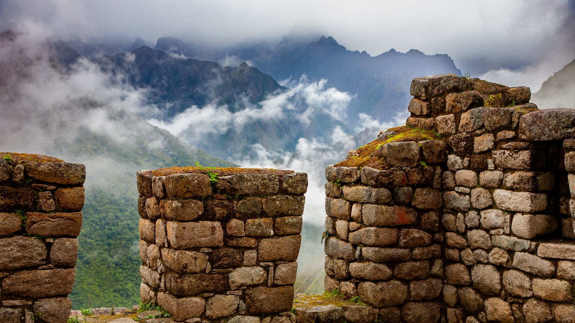 Machu Picchu and Sun Gate: Close-up of ancient stone structures in Machu Picchu with a background of mist-covered mountains, creating a mysterious and breathtaking atmosphere.