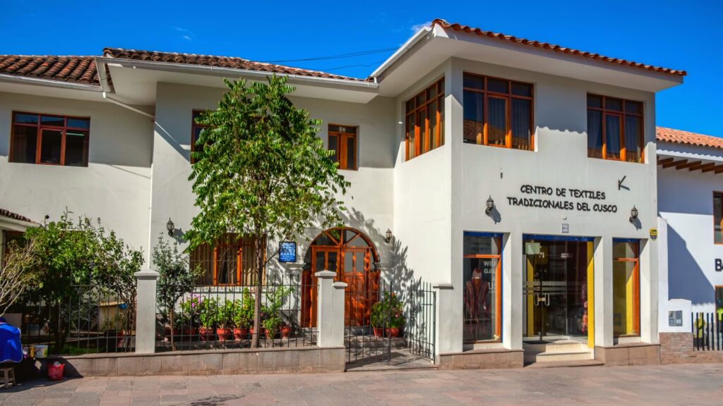 Text: Front view of the Centro de Textiles Tradicionales del Cusco, preserving Andean weaving traditions - Inka Trail Peru.info