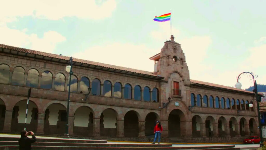 The Municipal Palace of Cusco with the Cusco flag waving atop, showcasing colonial architecture - Inka Trail Peru.info