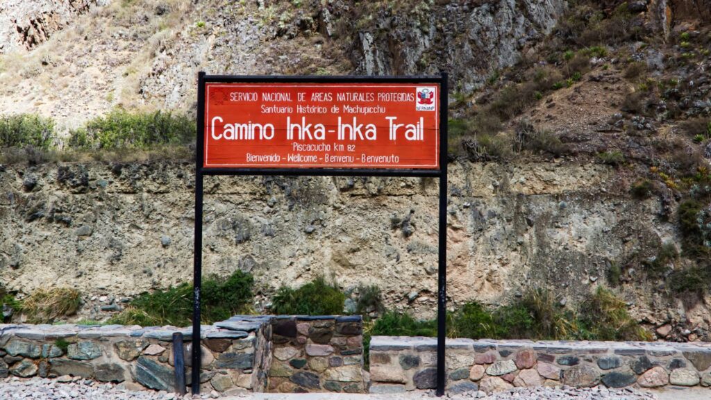 Official red sign marking the beginning of the Inca Trail at Km 82 in Piscacucho - Inka Trail Peru.info