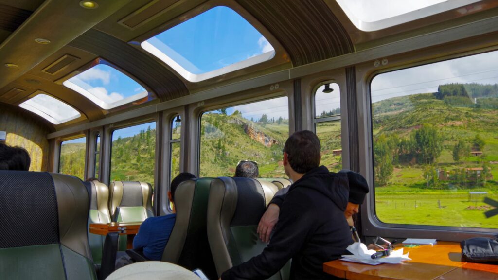 Passengers enjoying panoramic views of the Andes through large windows and glass ceilings on a train to Machu Picchu - Inka Trail Peru.info